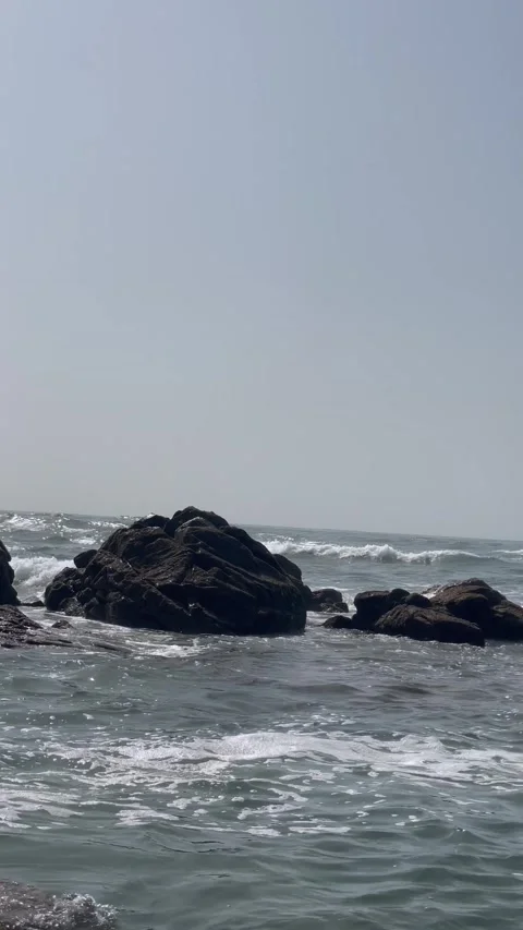 Vertical Shot of Ocean Waves Crashing Against Sea Boulders Stock Footage 340775095