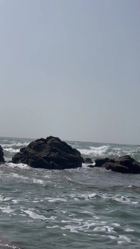 Vertical Shot of Ocean Waves Crashing Against Offshore Rocks Stock Footage 340775104