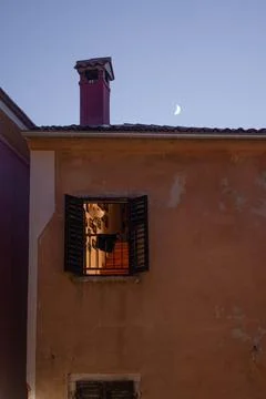 Vertical shot of an open window in an old orange building at night with the Mood Stock Photos