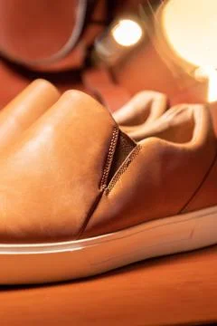 Vertical shot of a pair of brown solid slip shoes over the wooden table Fotos Stock