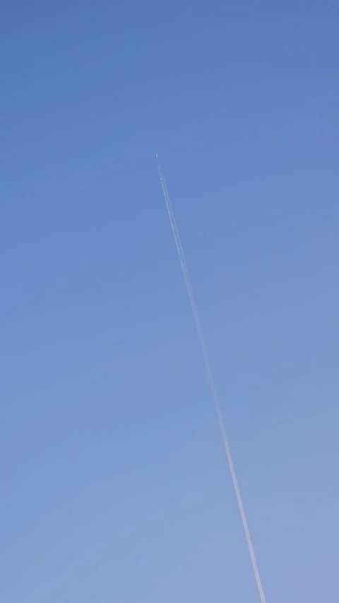 Vertical shot of a passenger airplane flying high in the blue sky Vídeos de archivo 338005756