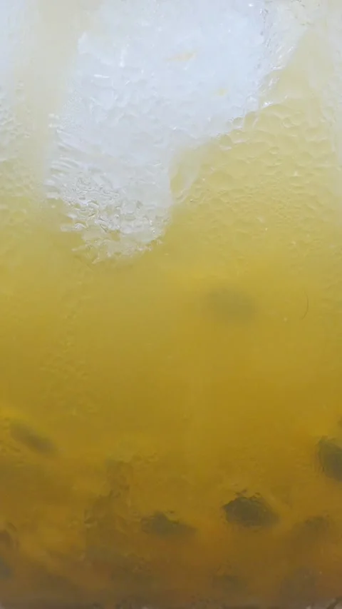 A vertical shot of a passion fruit juice cocktail. Passion fruit seeds moving Stock Footage 305601220