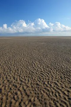 Vertical shot of a patterned desert with a cloudy sky background Stock Photos