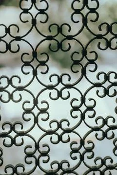 Vertical shot of patterns with elements on a fence window 스톡 사진