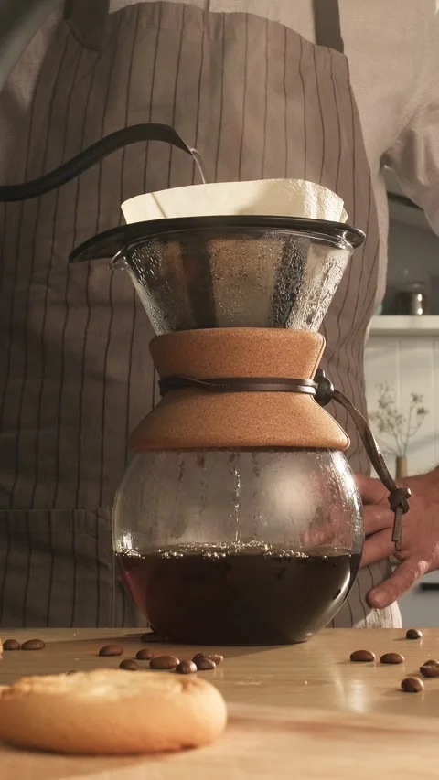 Vertical shot of a person brewing pour-over coffee in a Chemex-style carafe Stock Footage 306850491