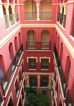 Vertical shot of a pink rectangular building with columns and balconies Foto stock