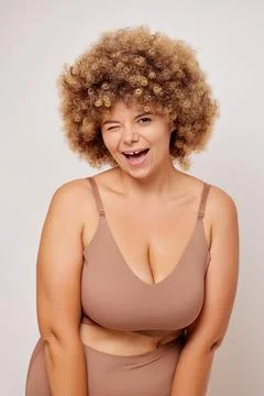 Vertical shot of plus size body positive adult woman with curly hair in lingerie Stock-Fotos