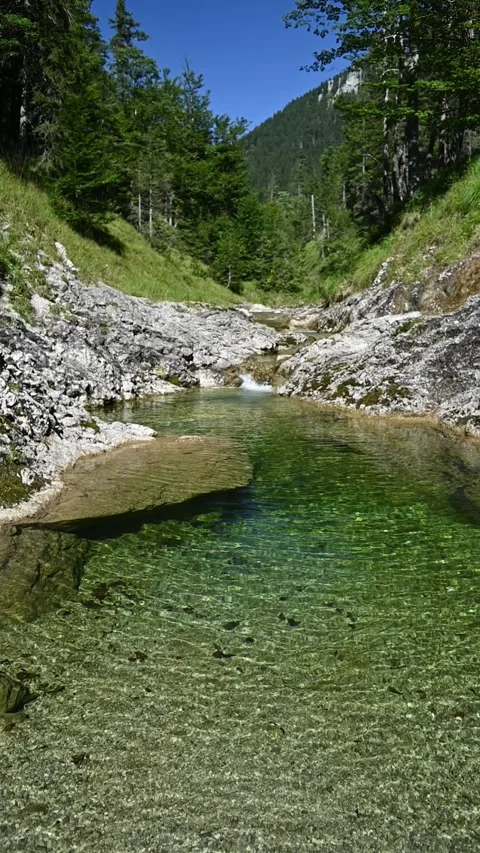 Vertical shot of the pond from a mountain stream with waves moving, slow motion Video stock 260893355