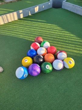 Vertical shot of pool balls on the table outdoors on a sunny day Stock Photos