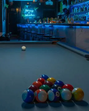 Vertical shot of a pool table with organized balls in an illuminated bar Stock Photos