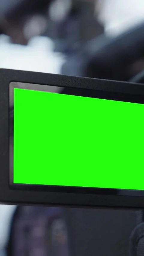 Vertical shot Professional video camera recording with a green screen monitor, Stock Footage 340564027
