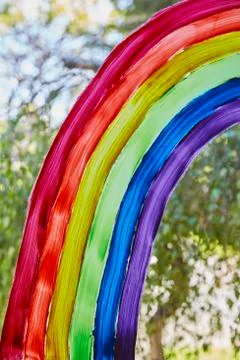 Vertical shot of a rainbow painted on a window. Stock Photos