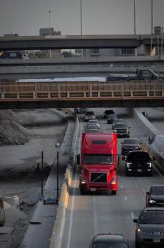 Vertical shot of a red truck on the congested road with a bridge in the backgrou Stock Photos