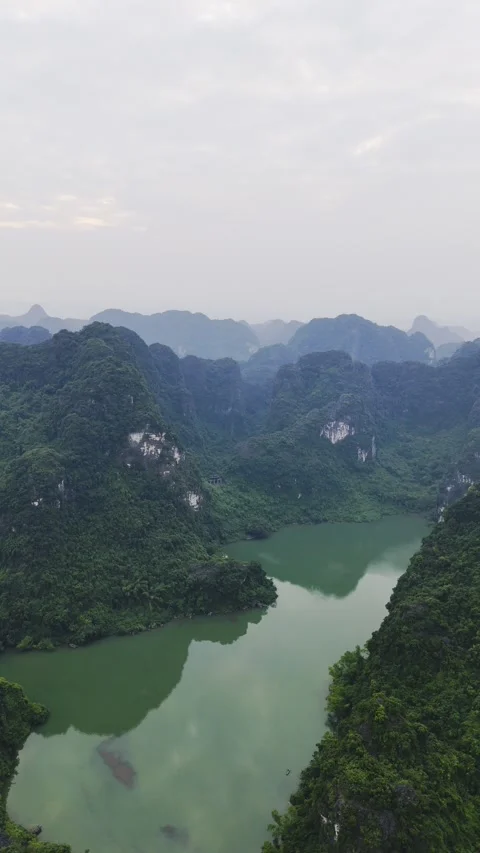 Vertical shot of river surrounded by mountains in Trang An, Vietnam – 4K Stock Footage 325040512