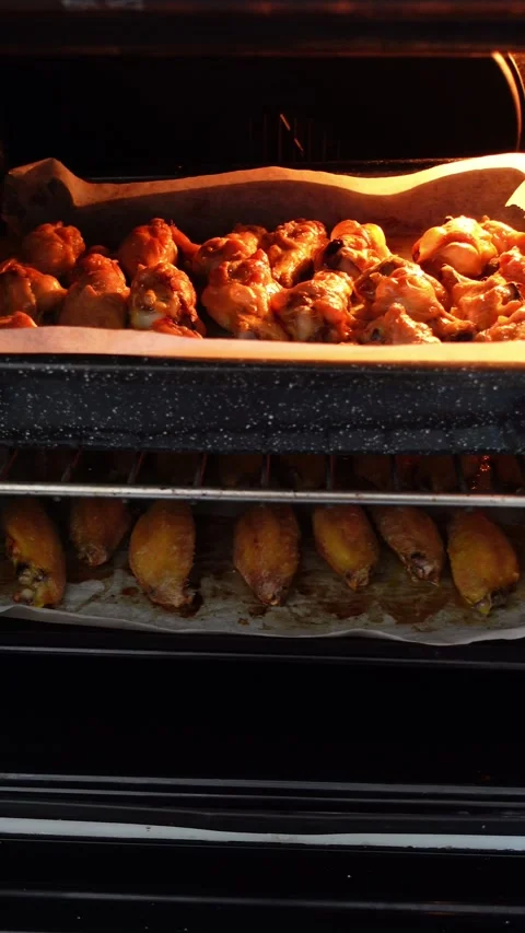 Vertical shot of roasted chicken wings inside and oven Stock Footage 283276610