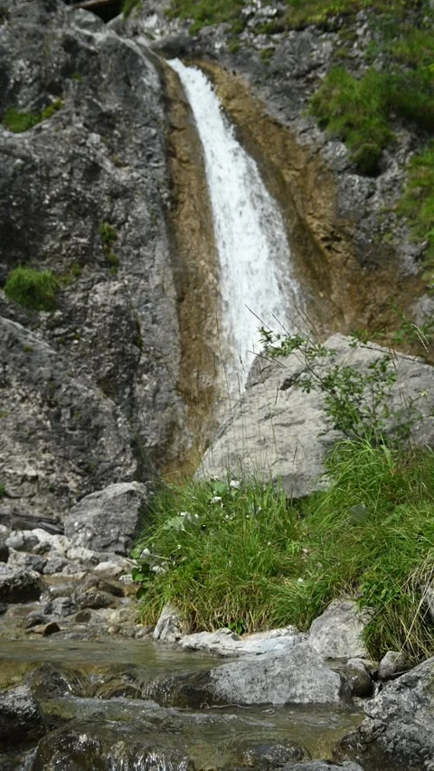 Vertical shot of rocks, a waterfall and a mountain stream Video stock 260889465