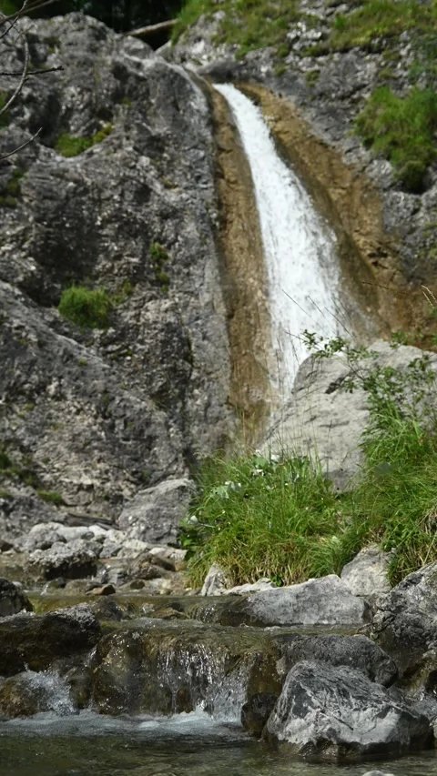 Vertical shot of rocks, a waterfall and a mountain stream Stock-Footage 260889559