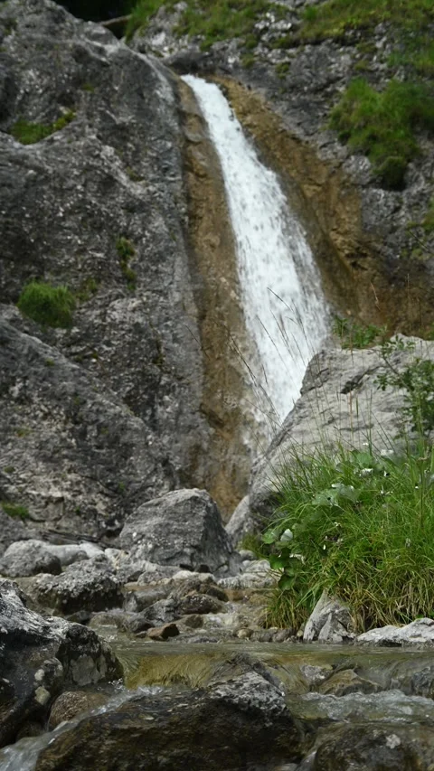 Vertical shot of rocks, a waterfall and a mountain stream, overcast Video stock 260889685