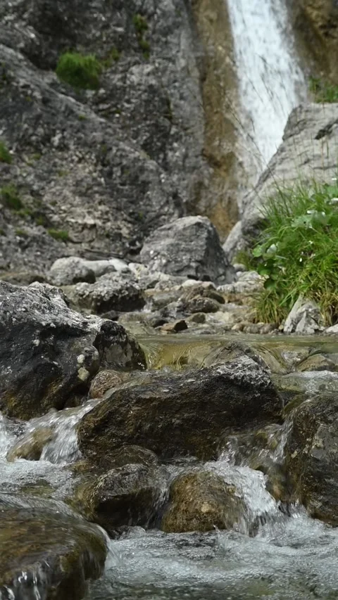 Vertical shot of rocks, a waterfall and a mountain stream, slow motion Video stock 260891201