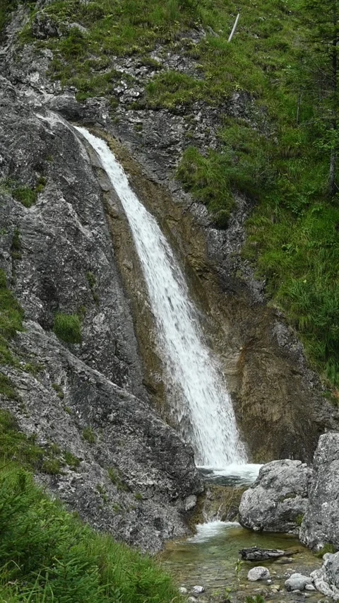 Vertical shot of rocks, a waterfall and a mountain stream, slow motion Stock-Footage 260891259