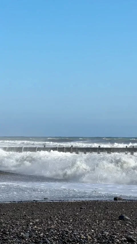 A vertical shot of rocky cliffs rising above the sea surface. A calm view of Stock Footage 275476122