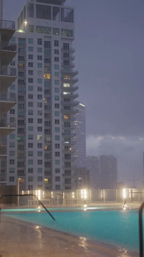 Vertical shot of rooftop infinity pool in Brickell Miami at dusk with dramatic s Stock Footage 318535560