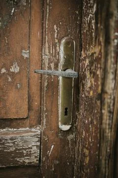 Vertical shot of a rusty handle on an old wooden door Photos