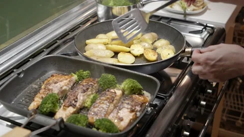 Vertical shot of salmon and broccoli baking in grill pan with potato Видео 221750864