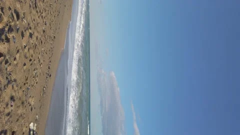 Vertical shot. sandy beach. blue sky. sea waves, white foam. vacation on coast. Stock Footage 144110616