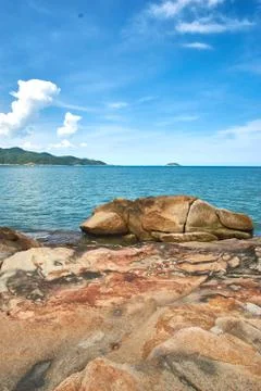 Vertical shot of the sea with a dramatic sky and rocks in the foreground - Hon Stock Photos
