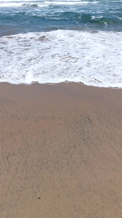 Vertical shot of the sea its waves on the shore of the beach Stock Footage 233599257