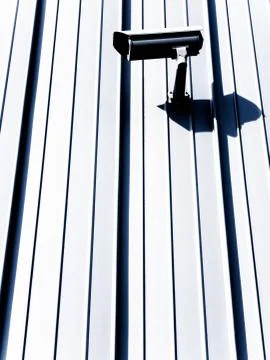 Vertical shot of a security camera on a white surface during daytime Stock Photos