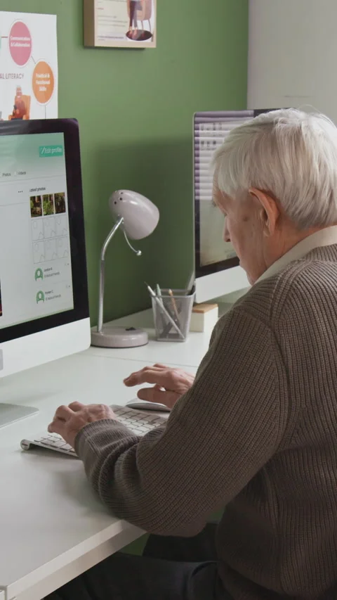 Vertical Shot of Senior Man Using Computer in Library Stock Footage 333766956