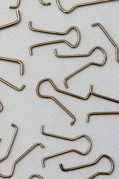Vertical shot of several paper clips arranged randomly on a white background Stock Photos