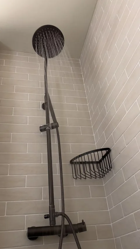 A vertical shot of the shower set inside bathroom on white wall, water falling Vídeo Stock 263112747