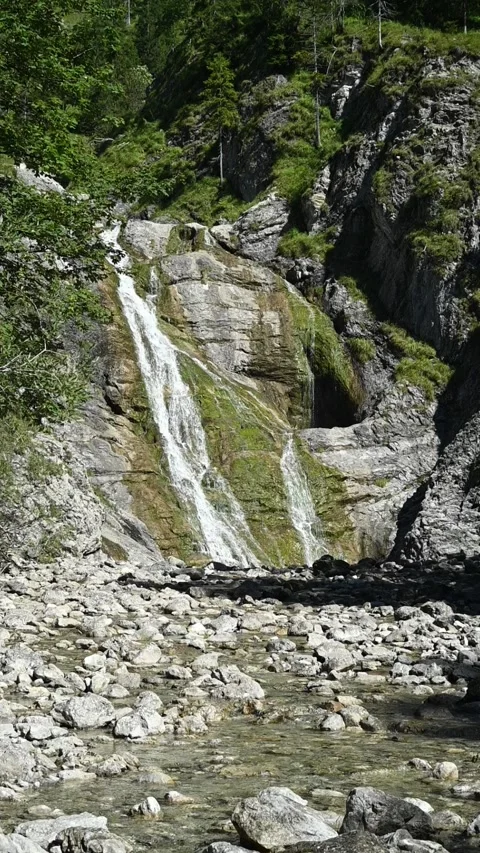 Vertical shot of a slow moving mossy waterfall in alpine surroundings, slow-mo Stock-Footage 260892959