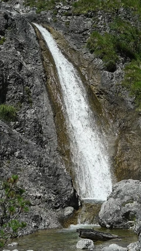 Vertical shot of a small stoney mountain stream, slow motion Stock Footage 260890910