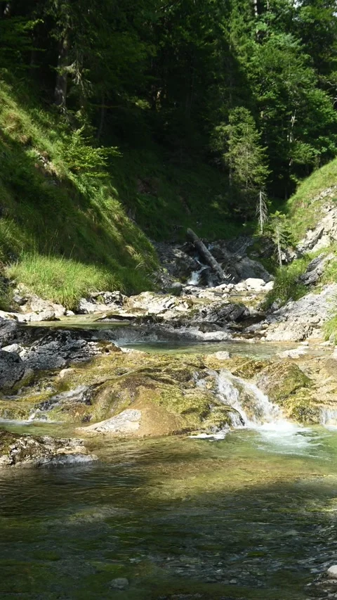 Vertical shot of a small waterfall from a mountain stream Video stock 260881231
