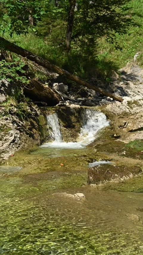 Vertical shot of a small waterfall from a mountain stream in the afternoon Stock-Footage 260882913