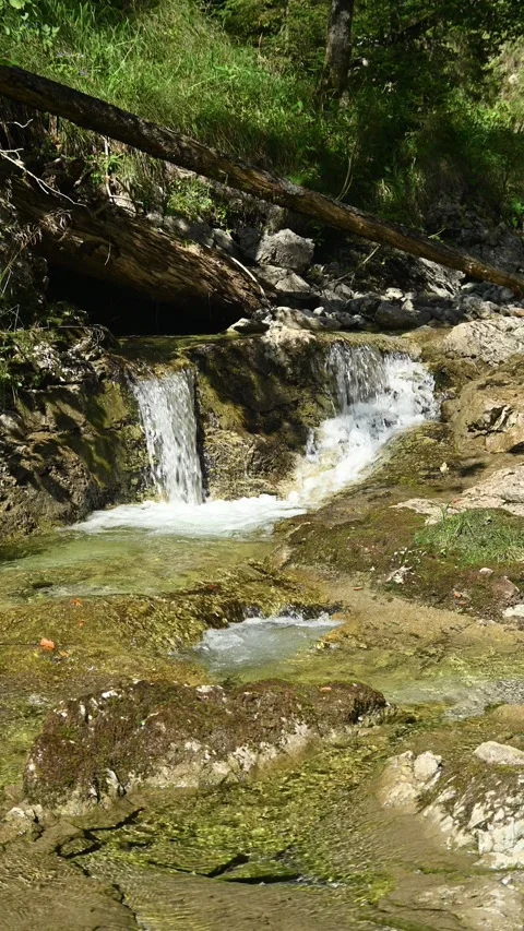 Vertical shot of a small waterfall from a mountain stream in the afternoon Stock-Footage 260883258