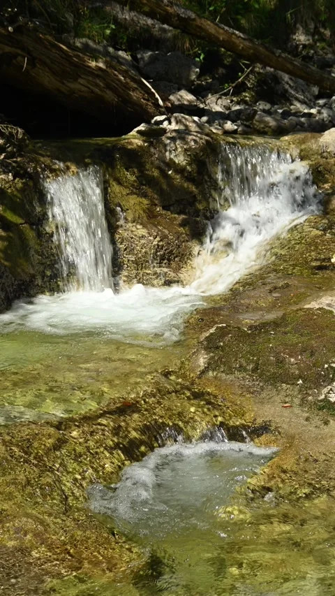 Vertical shot of a small waterfall from a mountain stream in the afternoon Stock-Footage 260883366