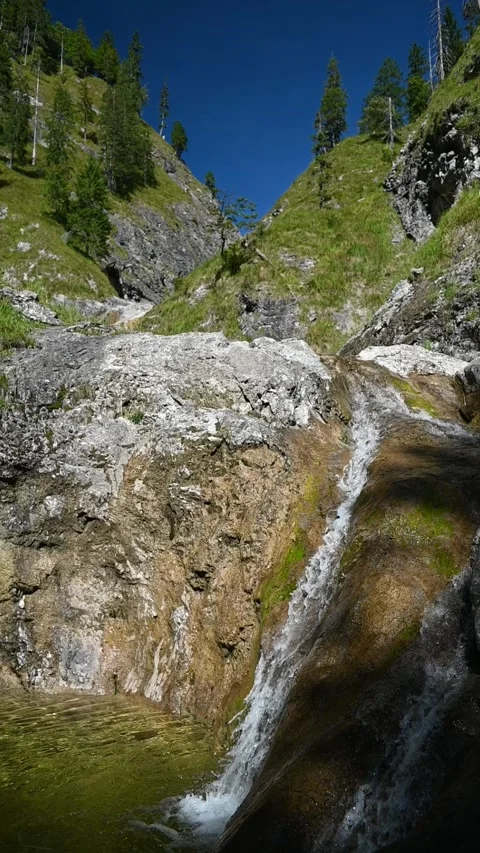 Vertical shot of smaller waterfalls between steep mountains in slow motion Stock-Footage 260893863