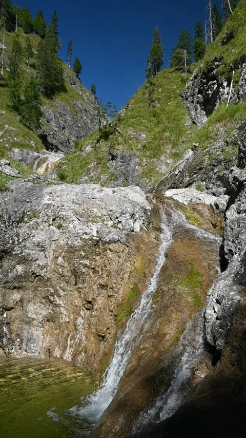 Vertical shot of smaller waterfalls between steep mountains in slow motion Stock-Footage 260893892