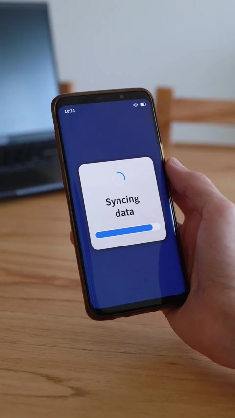 Vertical shot of smartphone syncing data with cloud storage. Laptop on the Video stock 321386222