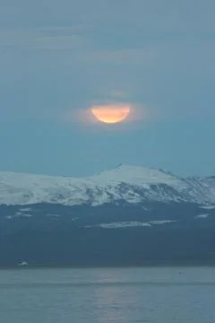 A vertical shot of snowy mountain range aesthetic with the sun covered in clo Stock Photos