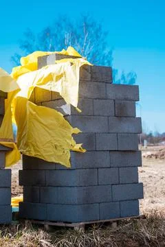 Vertical shot of a stack of gray bricks near a construction site Stock Photos