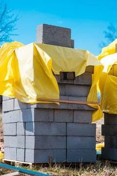 Vertical shot of a stack of gray bricks near a construction site Stock Photos