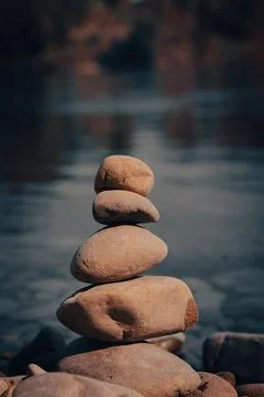 Vertical shot of a stack of pebbles isolated on a blurred background 写真素材