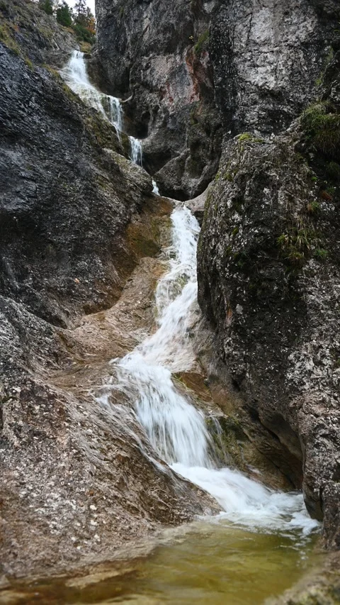 Vertical shot of a stepped waterfall in autumn, autumn colors, overcast Video stock 260894522