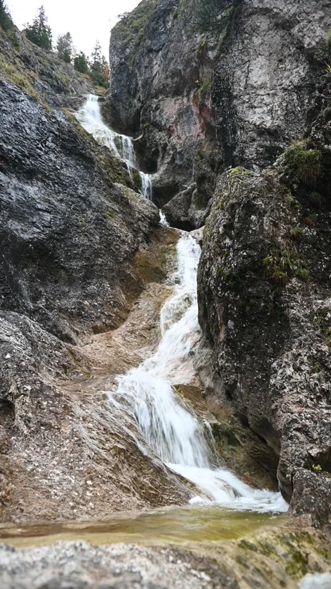 Vertical shot of a stepped waterfall in autumn, autumn colors, overcast Stock-Footage 260894624